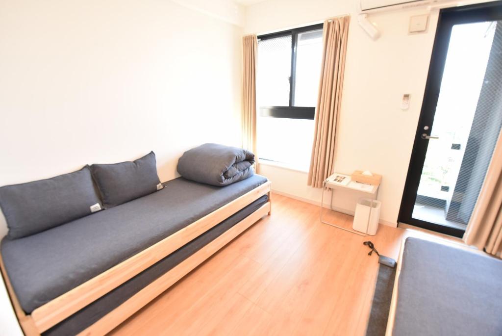 1 sofá en una sala de estar con 2 ventanas en ENZO / Vacation STAY 11623 en Fukuoka