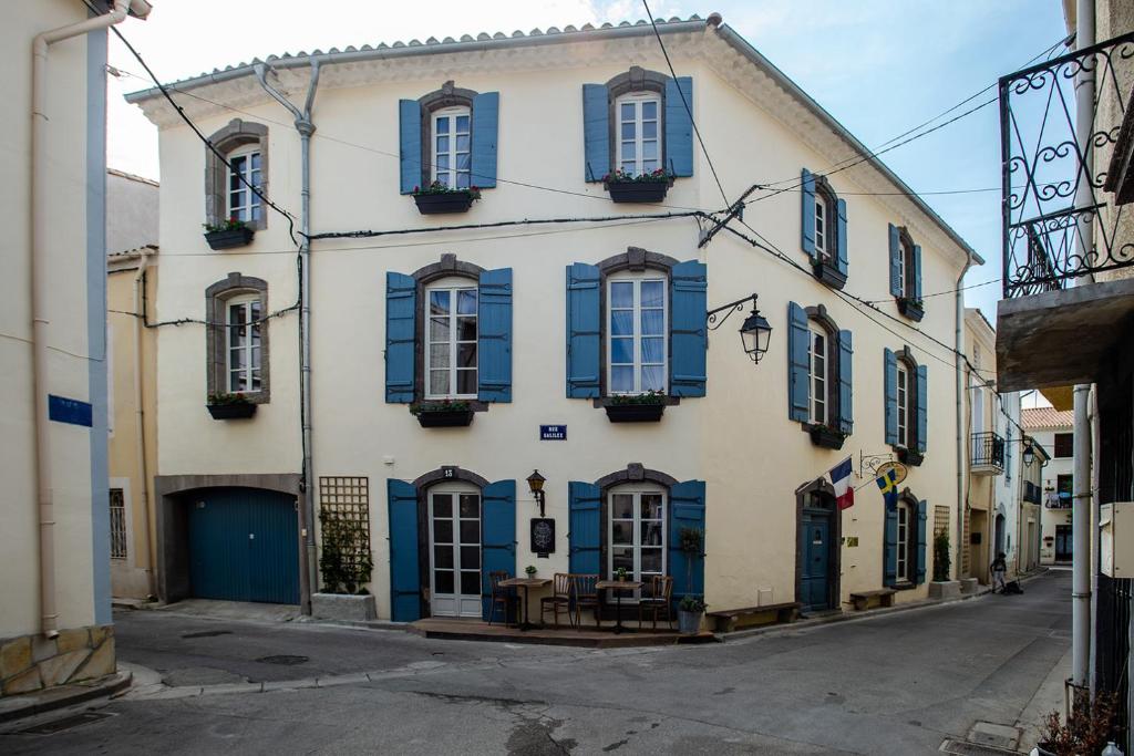 a building with blue shutters on a street at Rue Galilee in Marseillan