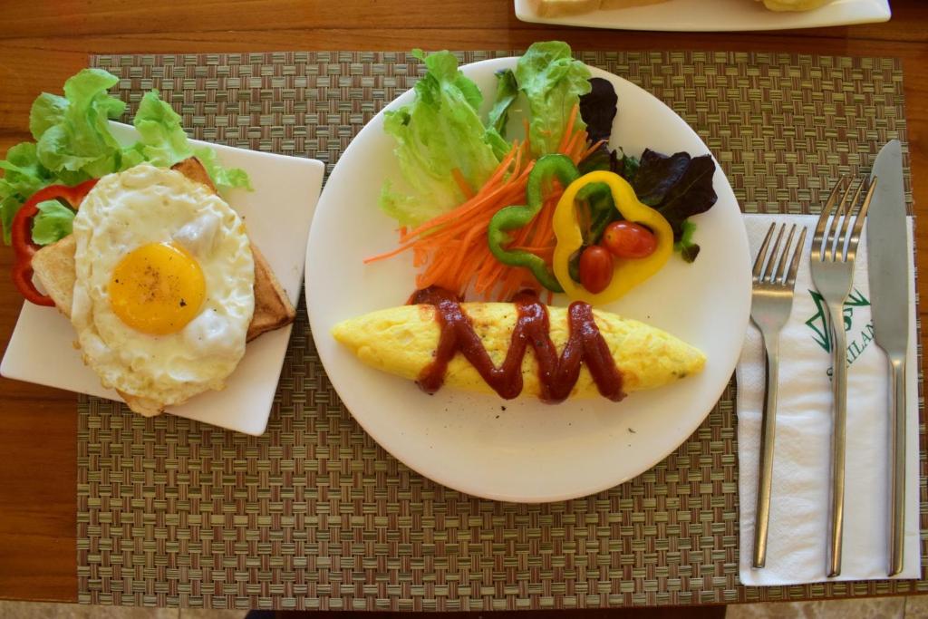 a plate of food with an egg and a salad at Villa Sirilanna Hotel in Chiang Mai