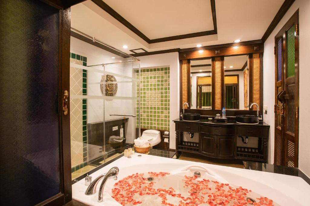 a bathroom with a large bath tub with a sink at Villa Sirilanna Hotel in Chiang Mai
