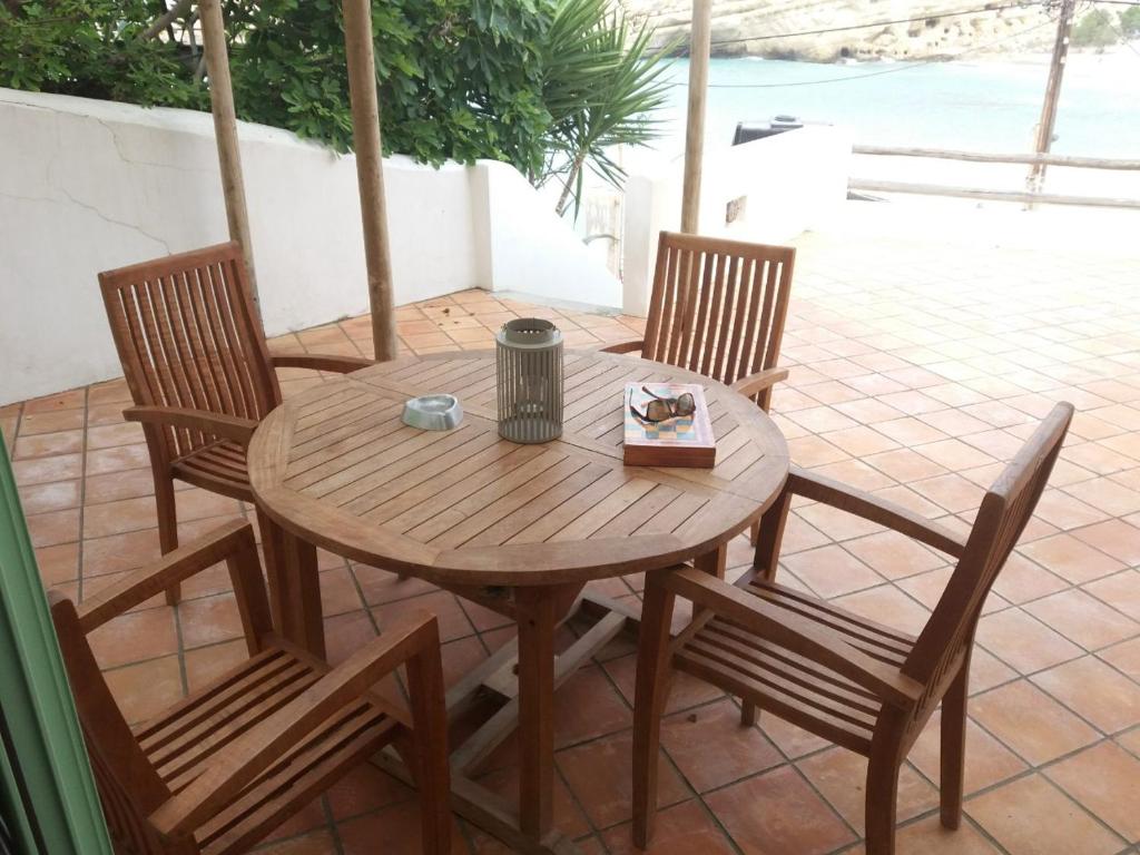 einen Holztisch und Stühle auf einer Terrasse in der Unterkunft Absolute Matala in Matala