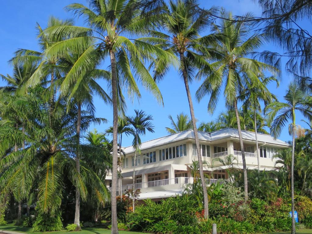 
a large white house sitting in front of a palm tree at Balboa Apartments in Port Douglas
