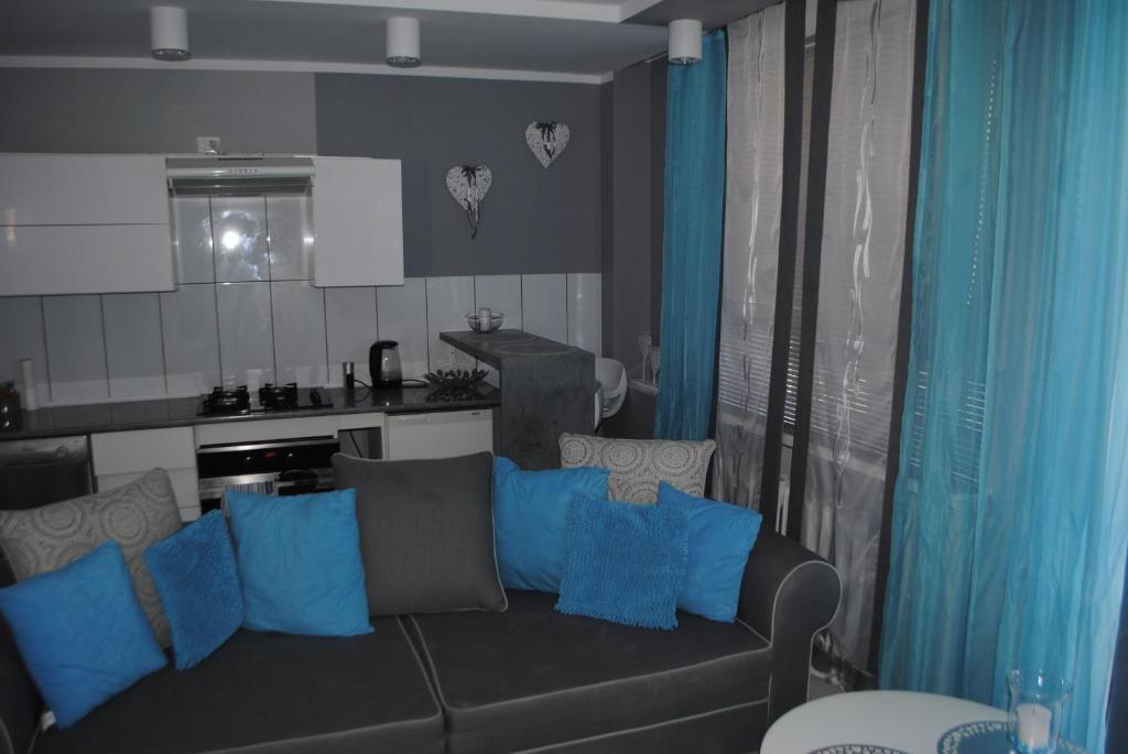 un salon avec un canapé avec des coussins bleus dans l'établissement APARTAMENT BULWAR, à Gorzów Wielkopolski