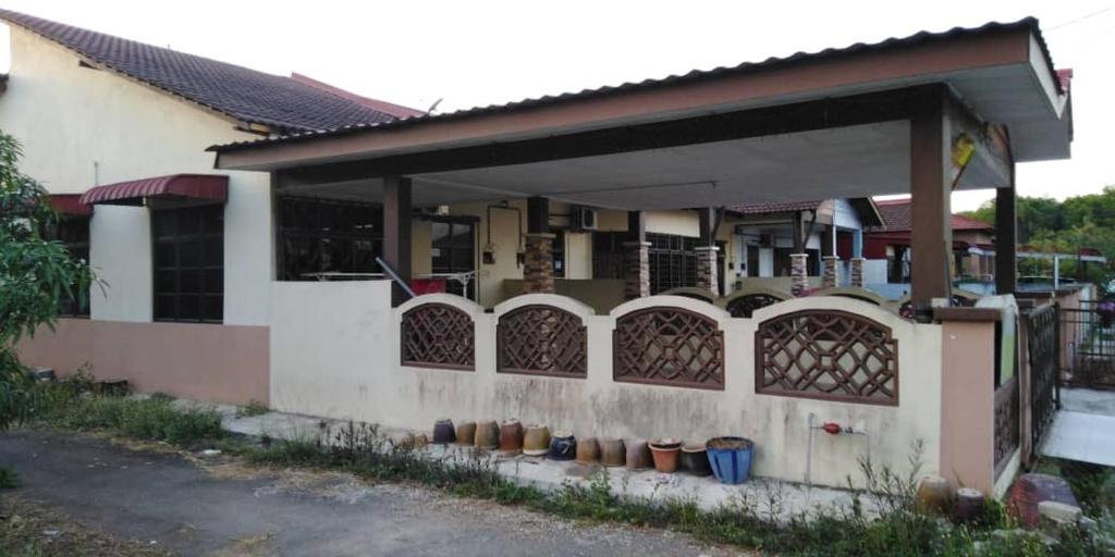 a house with a porch with potted plants on it at Zara Homestay in Machang