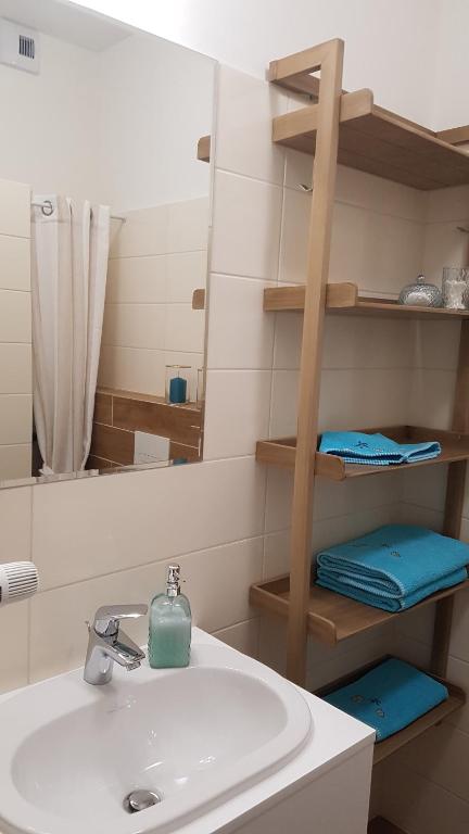 een badkamer met een wastafel en een spiegel bij Aquamarina Onyx 109 in Międzyzdroje