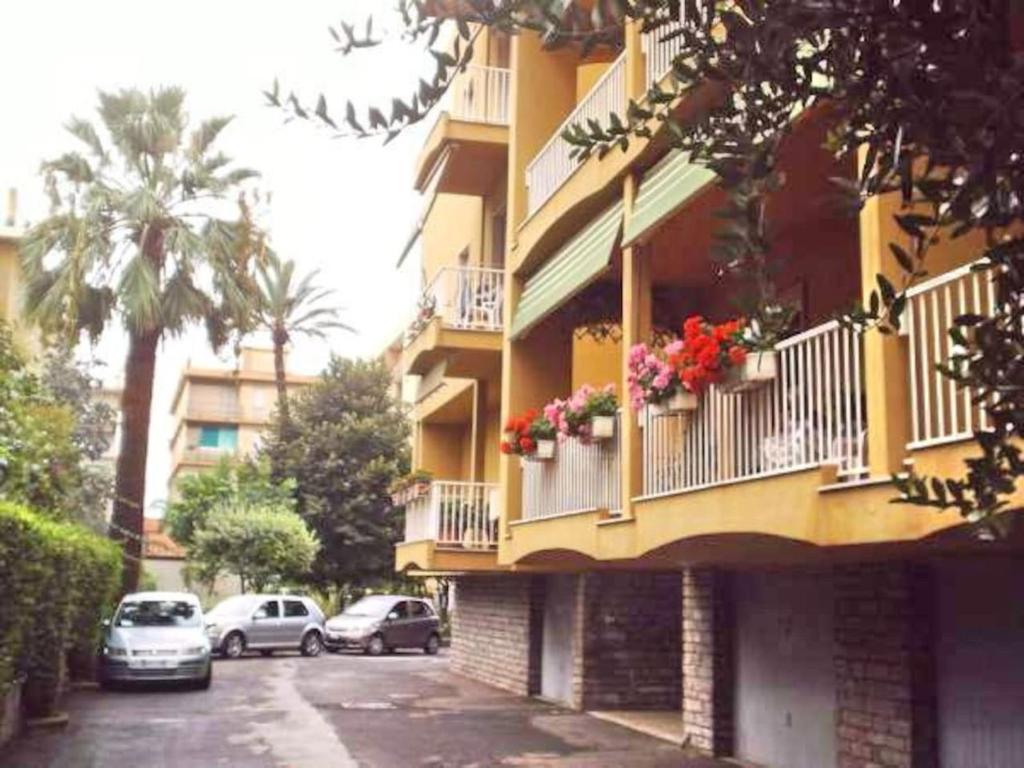 a yellow building with flower boxes on the balconies at Bordighera centro molto tranquillo in Bordighera