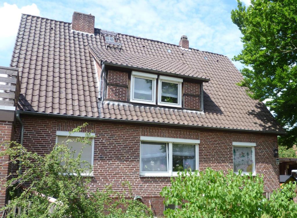 a red brick house with two windows and a roof at Ferienwohnung Kutscherhof Bartels in Bispingen