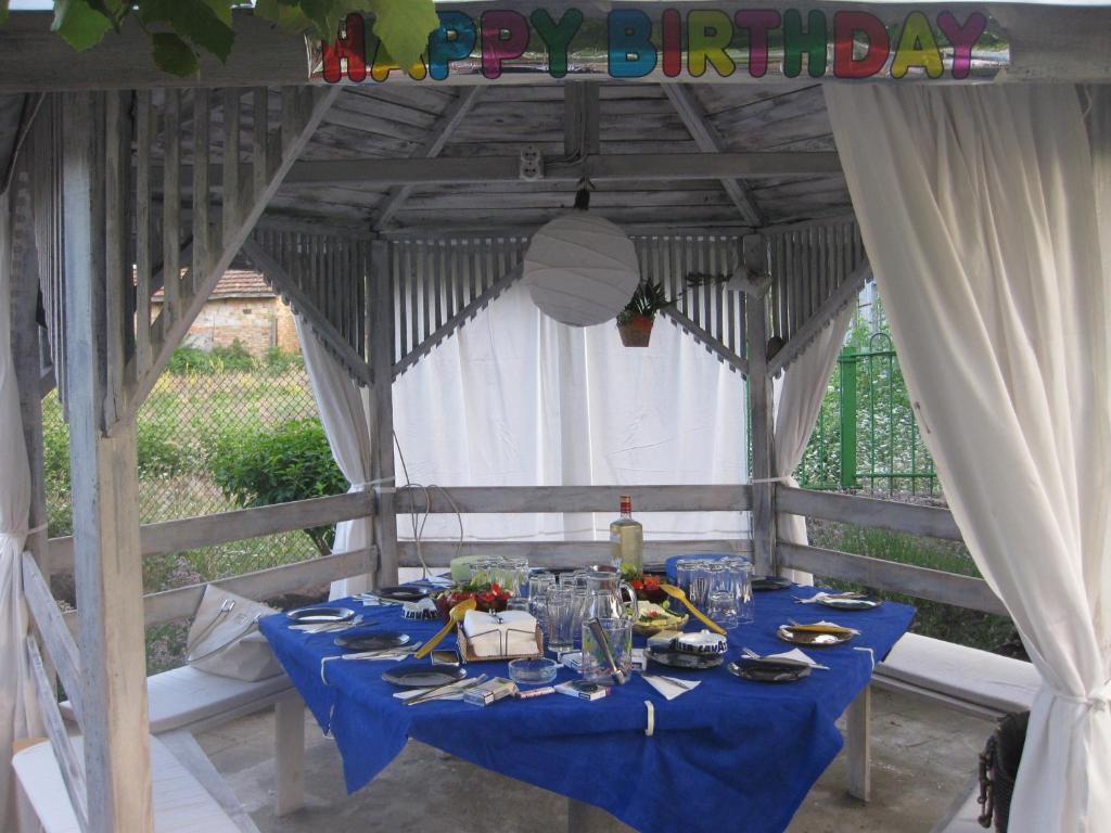 una mesa con un paño de mesa azul en un cenador en Rosi Guest House, en Lozenets