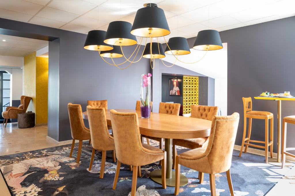 - une salle à manger avec une table et des chaises dans l'établissement Hotel des Lys, à Versailles