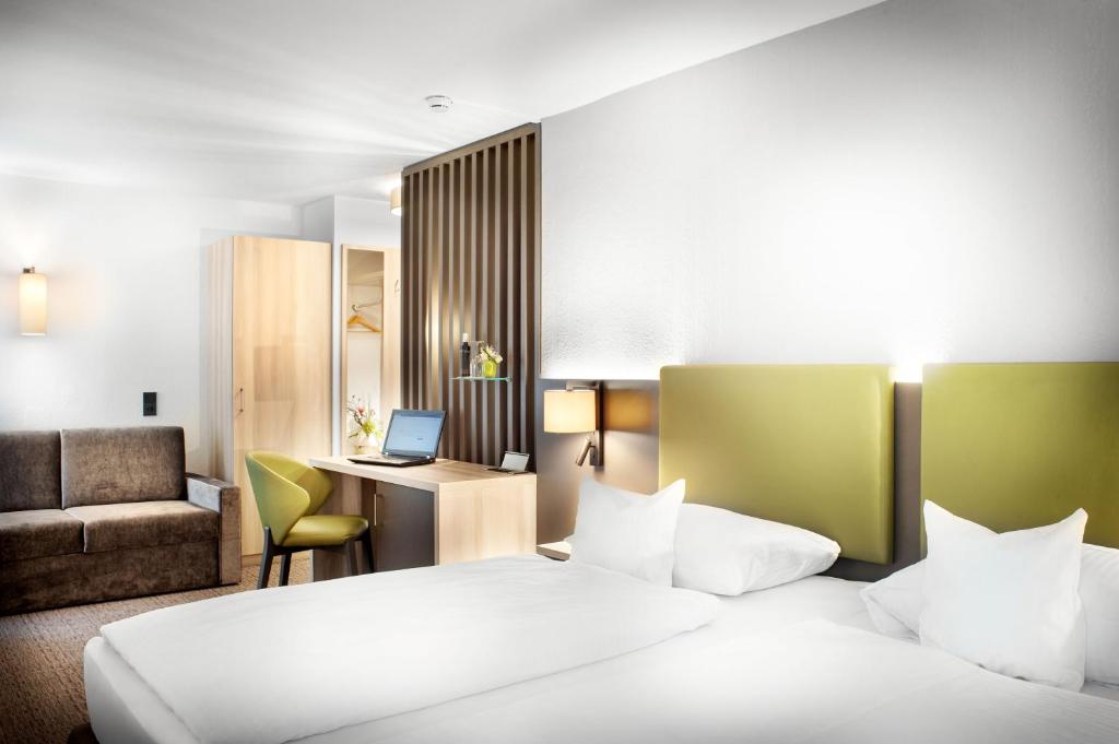 Habitación de hotel con 2 camas y escritorio en Best Western Hotel Favorit en Ludwigsburg