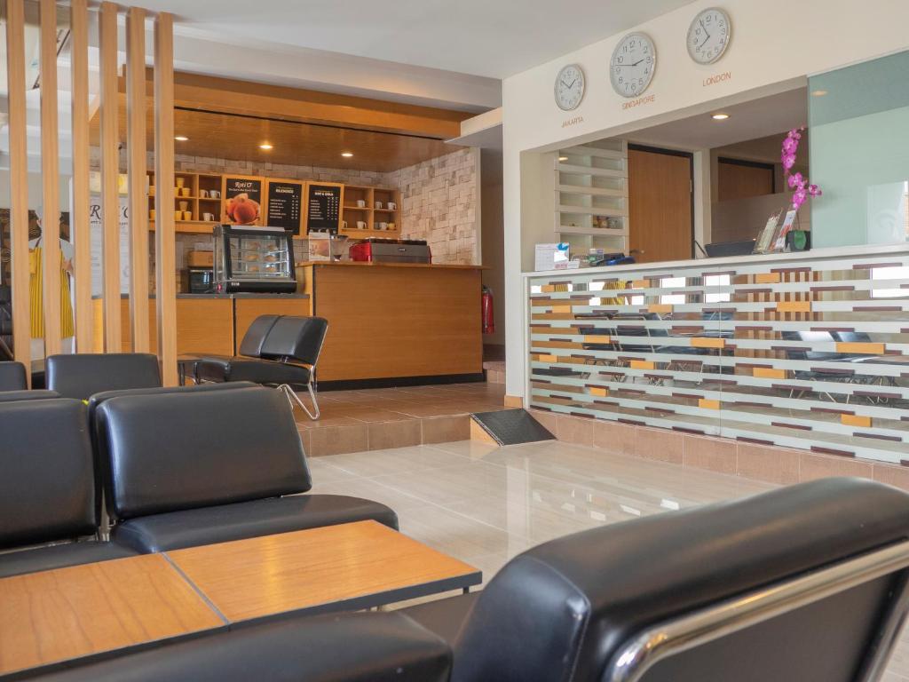 タンゲランにあるd'primahotel Airport Jakarta Terminal 1Aの革張りの椅子とカウンターが備わる待合室