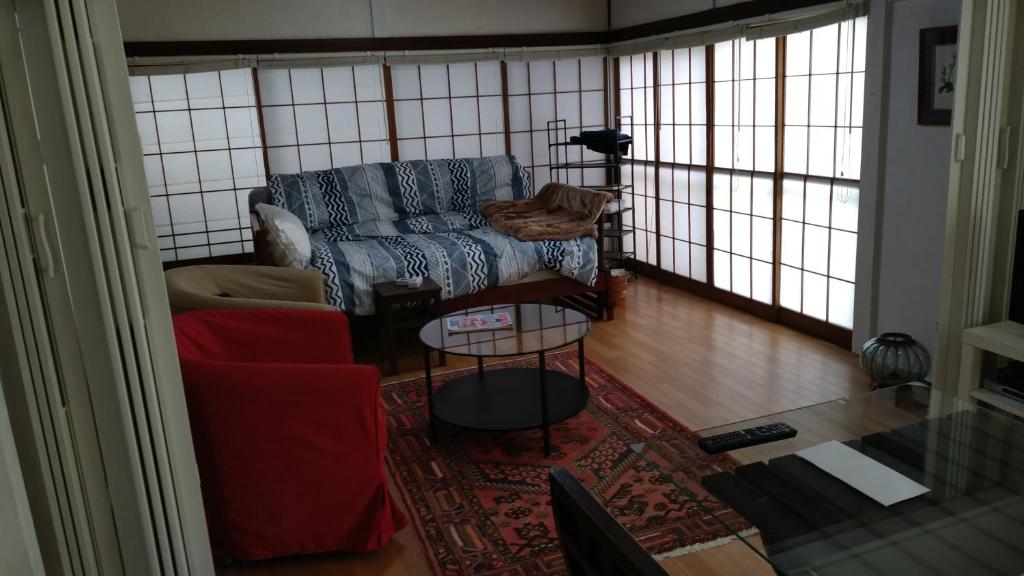 un soggiorno con divano e tavolo di EMS Enoshima ゲストハウス PetOK a Fujisawa