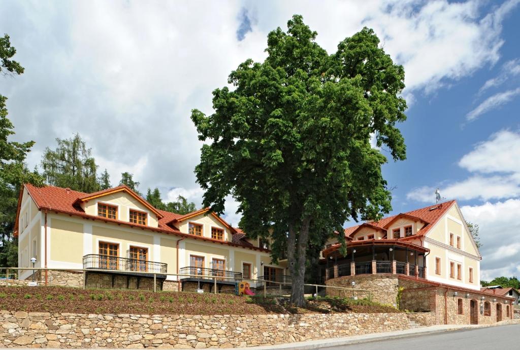 a large house with a tree in front of it at Hotel Gold Chotoviny in Chotoviny