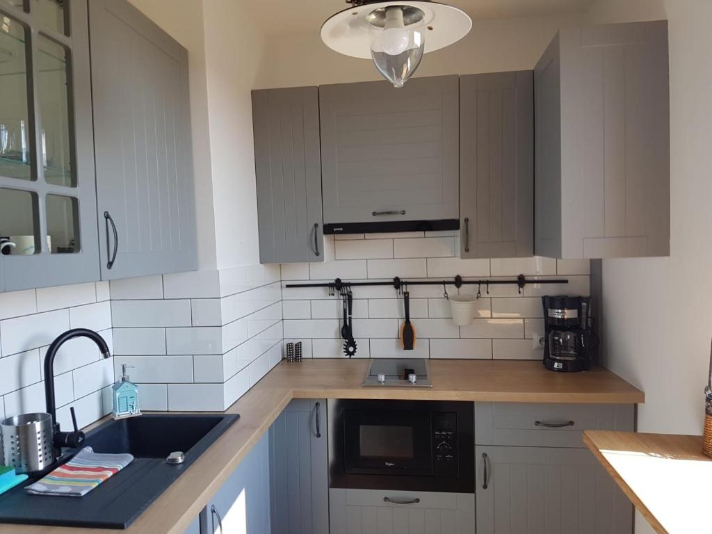 a kitchen with white cabinets and a sink at Fok Sztormowy in Hel