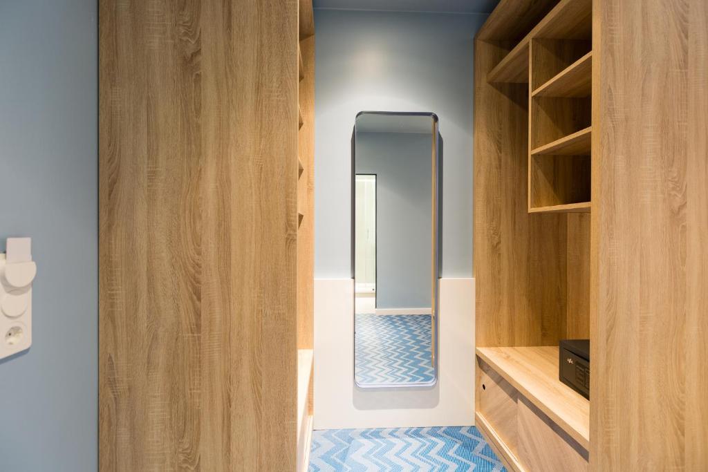 a dressing room with a mirror and wooden cabinets at about:berlin Hotel in Berlin