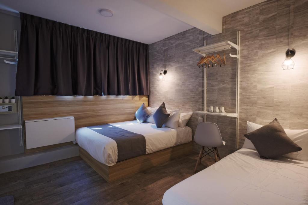 Q Loft Hotels at Bedok في سنغافورة: غرفة فندقية بسريرين ونافذة