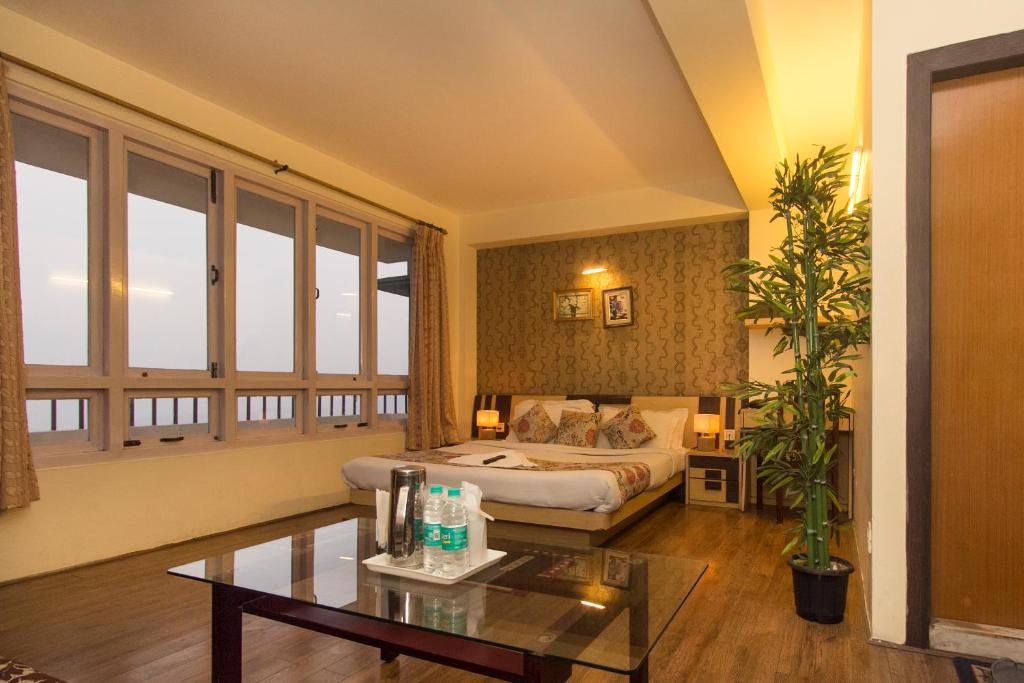 a hotel room with a bed and a table at Jagjeet's Sikkim Retreat in Gangtok