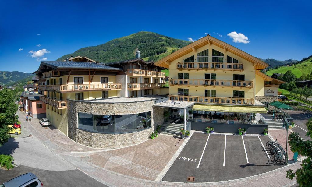 a large building with a parking lot in front of it at Hotel ALPINA in Saalbach-Hinterglemm