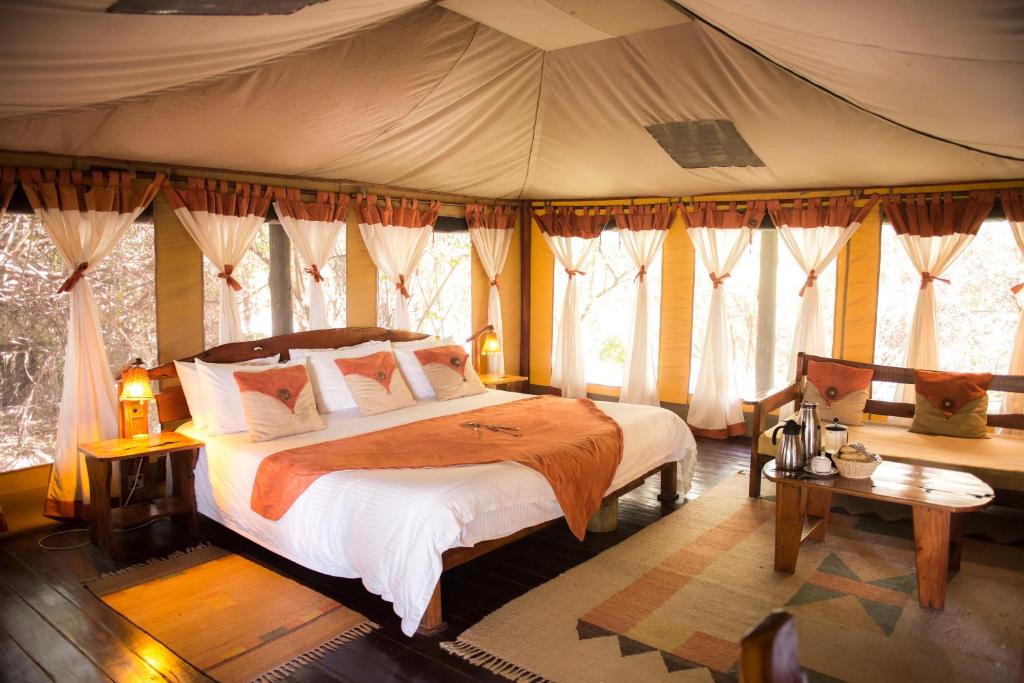 เตียงในห้องที่ Tipilikwani Mara Camp