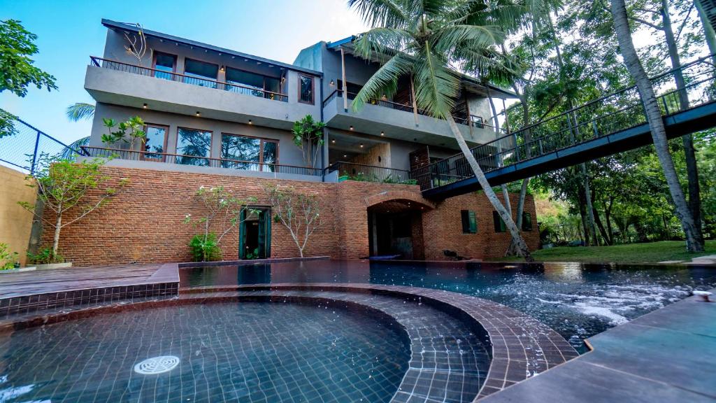 a house with a swimming pool in front of a building at Ayur Ayur Resort & Ayurveda Retreat in Negombo