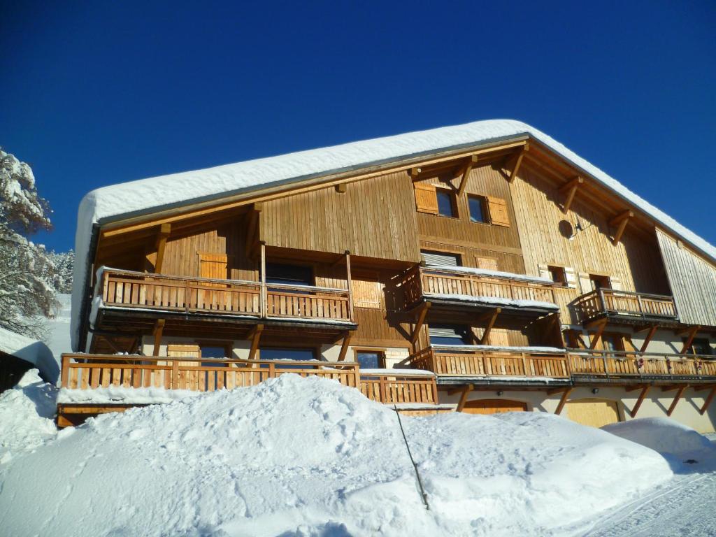 a large wooden building with snow in front of it at La Cour in Notre-Dame-de-Bellecombe