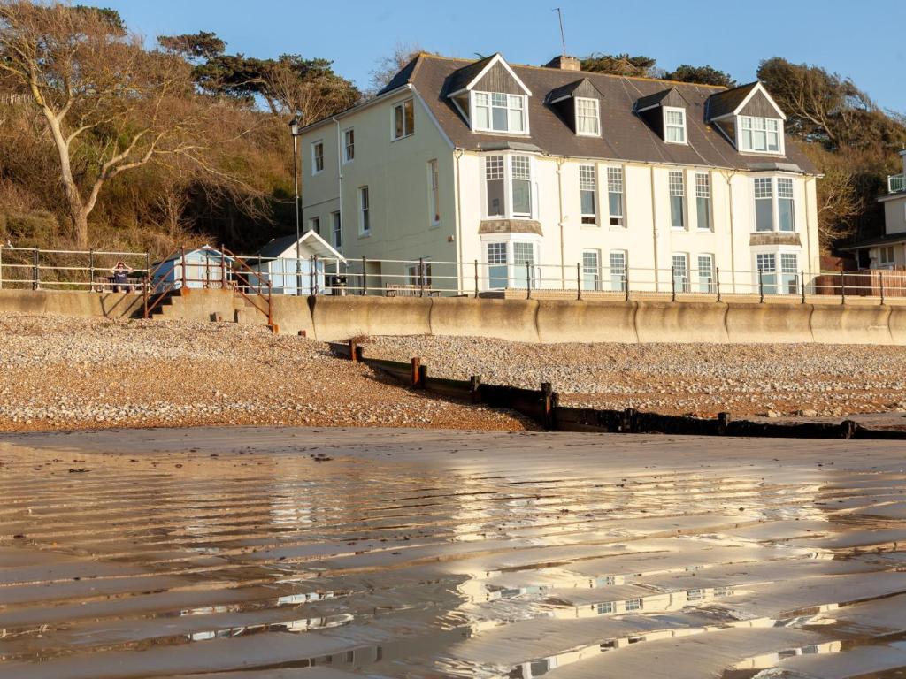a house on the shore of the beach at Promenade Apartment with own Beach Hut in Totland