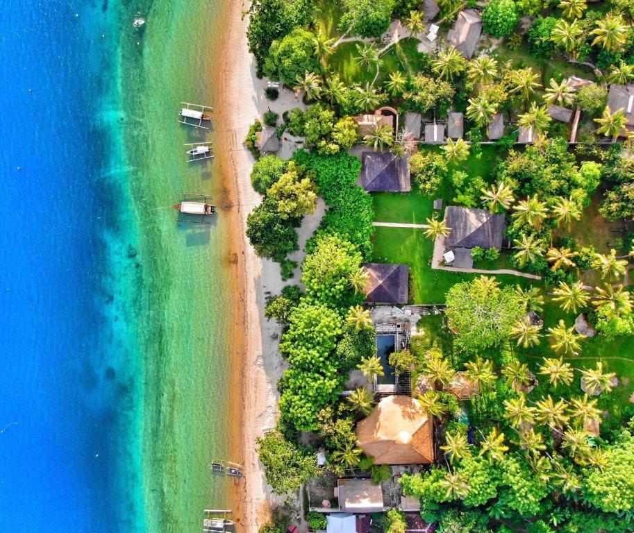 an aerial view of a beach with houses and the ocean at Vayam Boutique Resort Gili Asahan in Gili Asahan