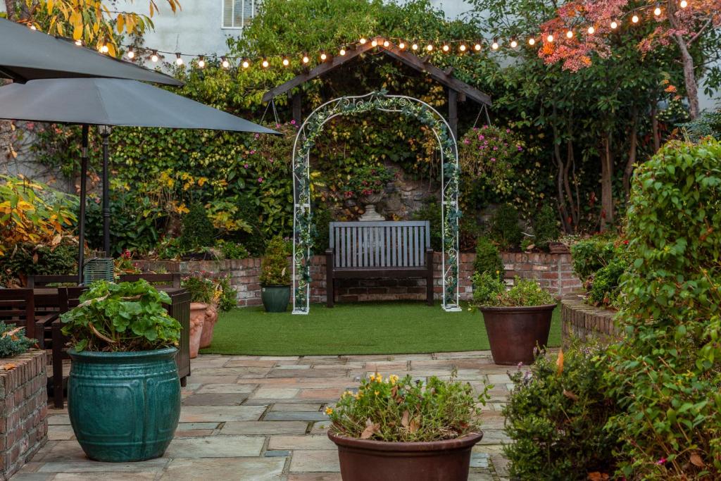 a garden with an arch and a bench and plants at Glenroyal Hotel in Maynooth