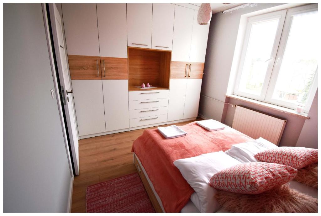 a bedroom with a bed with white cabinets and a window at Color 24 Premium in Stalowa Wola
