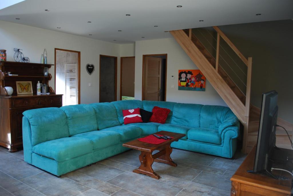 a living room with a blue couch and a table at LE LOFT in Wintzenheim