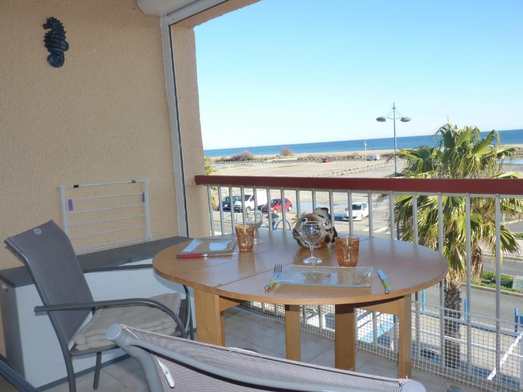 einen Tisch und Stühle auf einem Balkon mit Blick auf den Strand in der Unterkunft Duplex T2 mezzanine, Saint Pierre la Mer in Saint Pierre La Mer