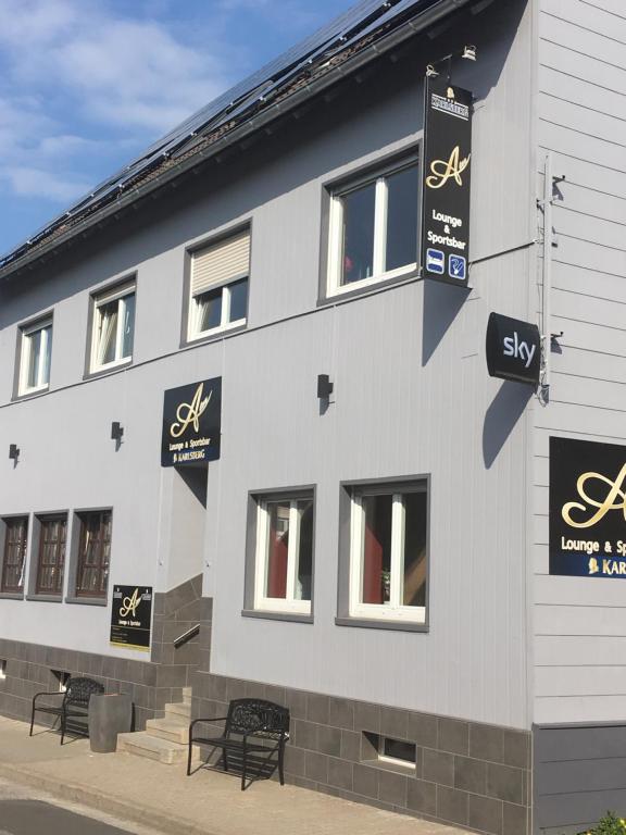 a white building with signs on the side of it at Alex -Lounge -Sportsbar -Smokerlounge in Otterbach