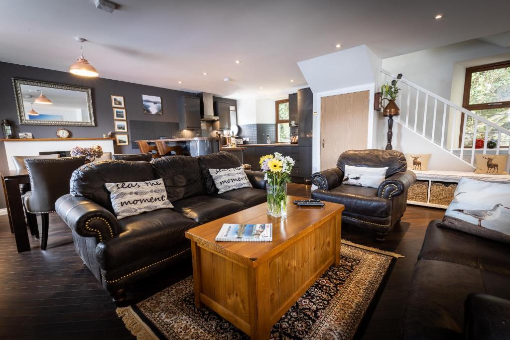 a living room with leather couches and a coffee table at Bayview in Portree