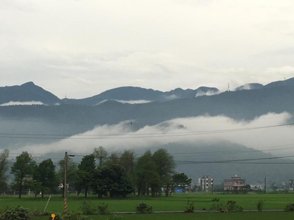 a foggy field with mountains in the background at Yilan Real Fun Homestay in Dongshan