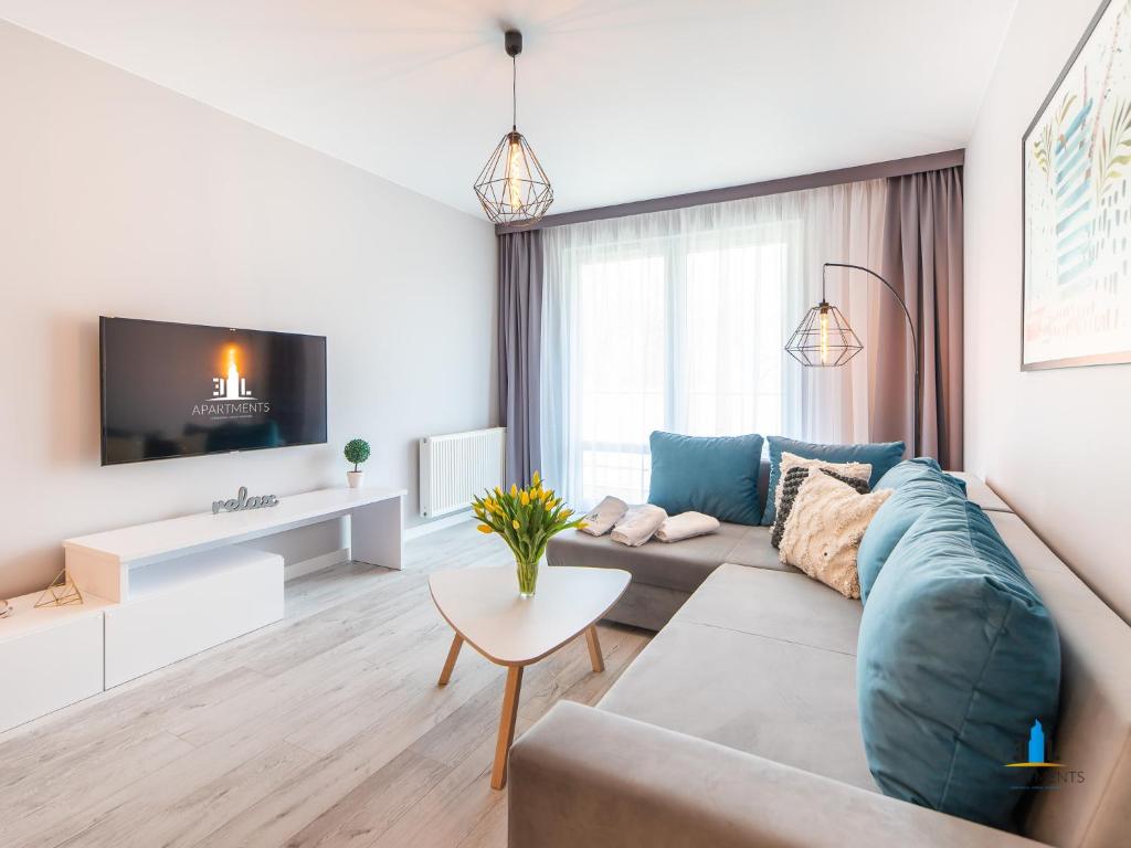 a living room with a couch and a tv at 3L Apartments Aquarius in Kołobrzeg