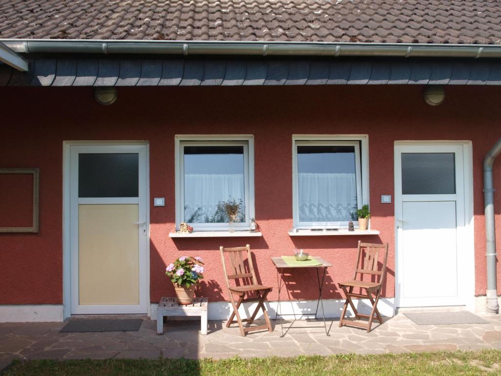 a red house with chairs and a table and windows at Bed Taste in Düsseldorf