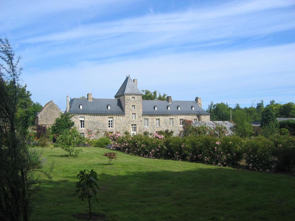 um grande castelo num campo de relva verde em Chambres d'hôtes Château de Bonabry em Hillion