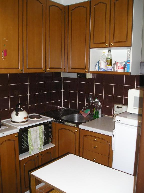 a kitchen with wooden cabinets and a white stove top oven at Apartmány Bratislava in Bratislava