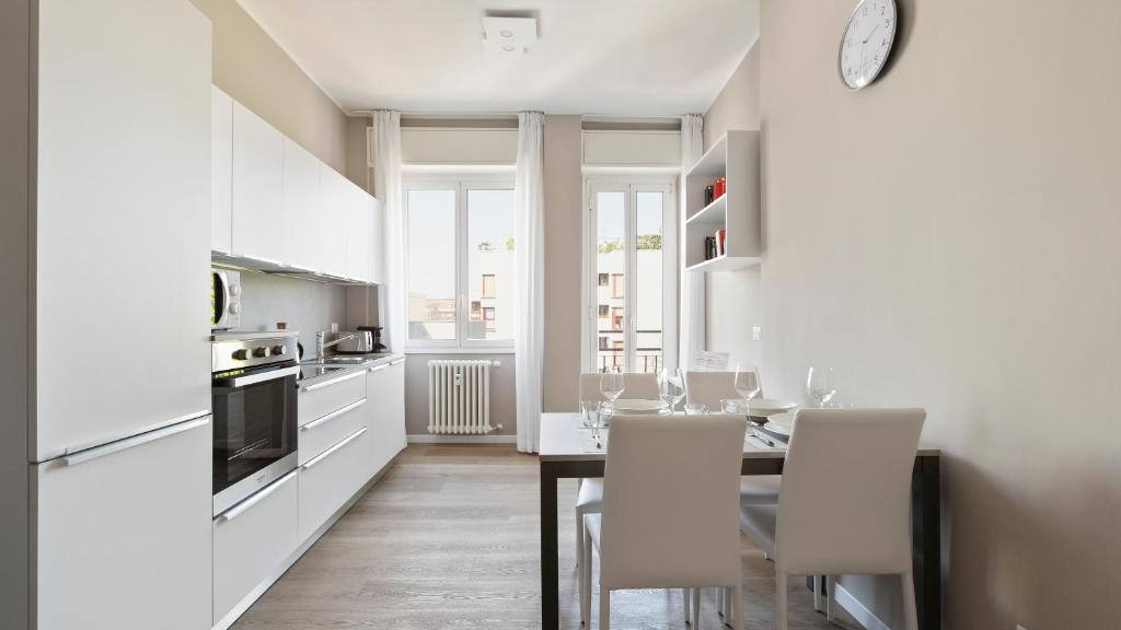 cocina blanca con mesa de comedor y sillas en Italianway - Largo Allegri 4, en Milán
