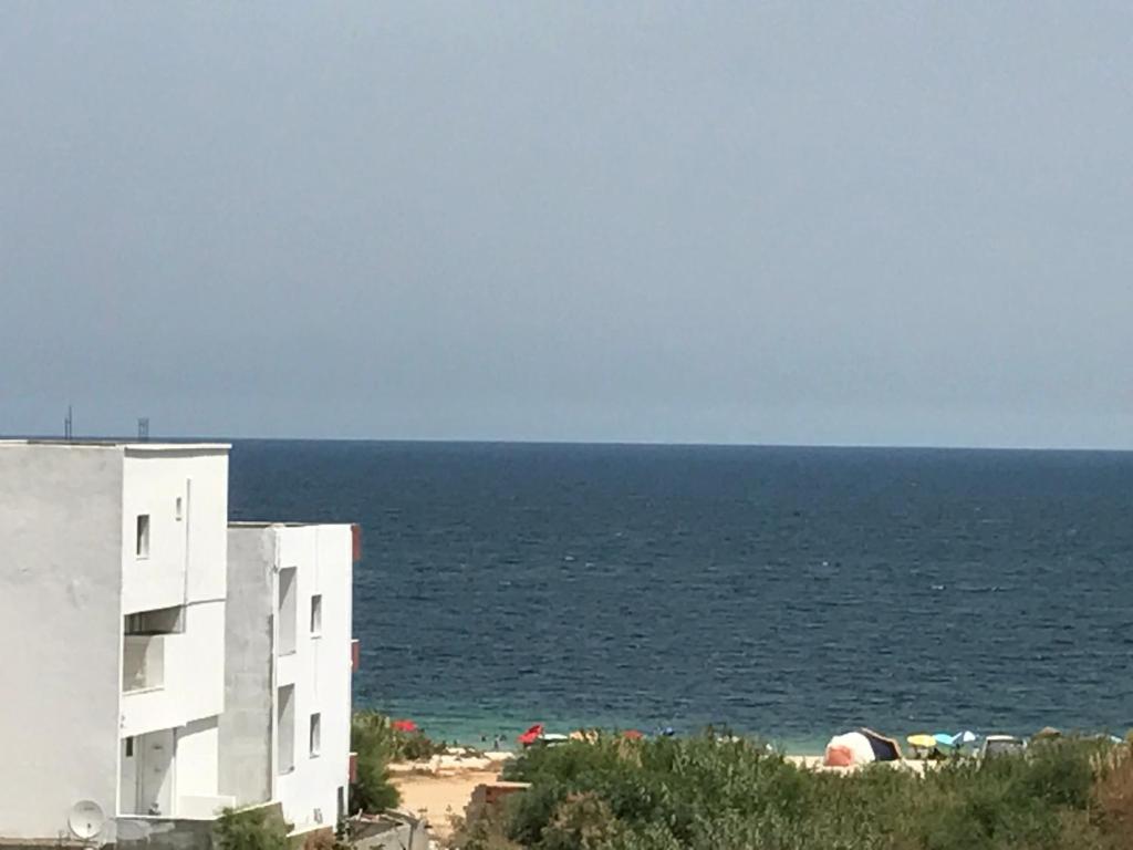 a white building on the beach near the ocean at DIAR EL FELL - Route Touristique - Chatt Meryem / Port El Kantaoui in Sousse