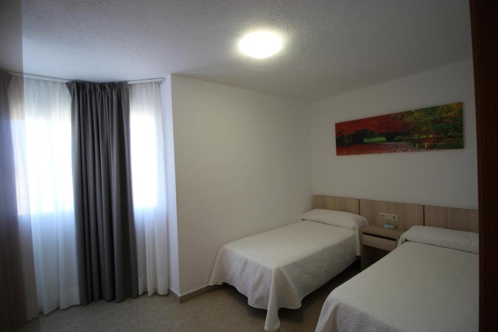 ベニドルムにあるApartamentos Playamarのベッド2台と窓が備わるホテルルームです。