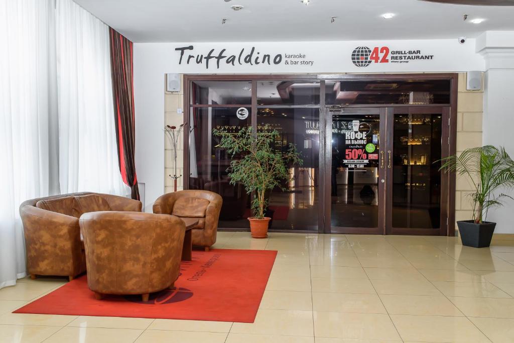 a lobby with two chairs and a building at AZIMUT Hotel Kemerovo in Kemerovo