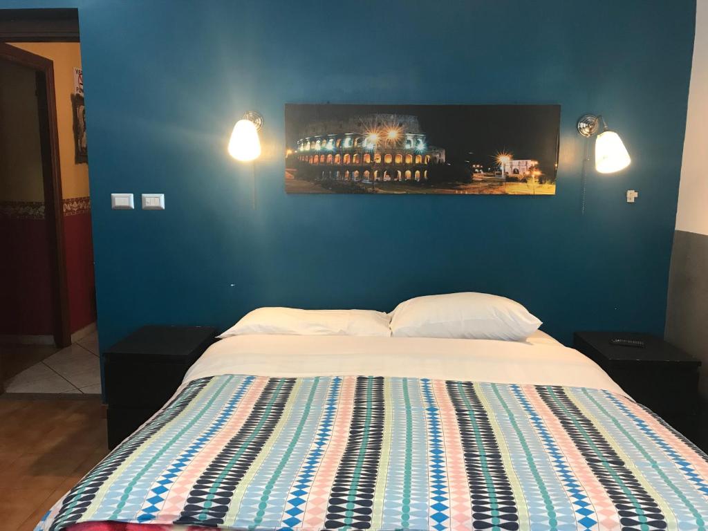 sypialnia z łóżkiem z niebieską ścianą w obiekcie La Casa di Elena w Rzymie