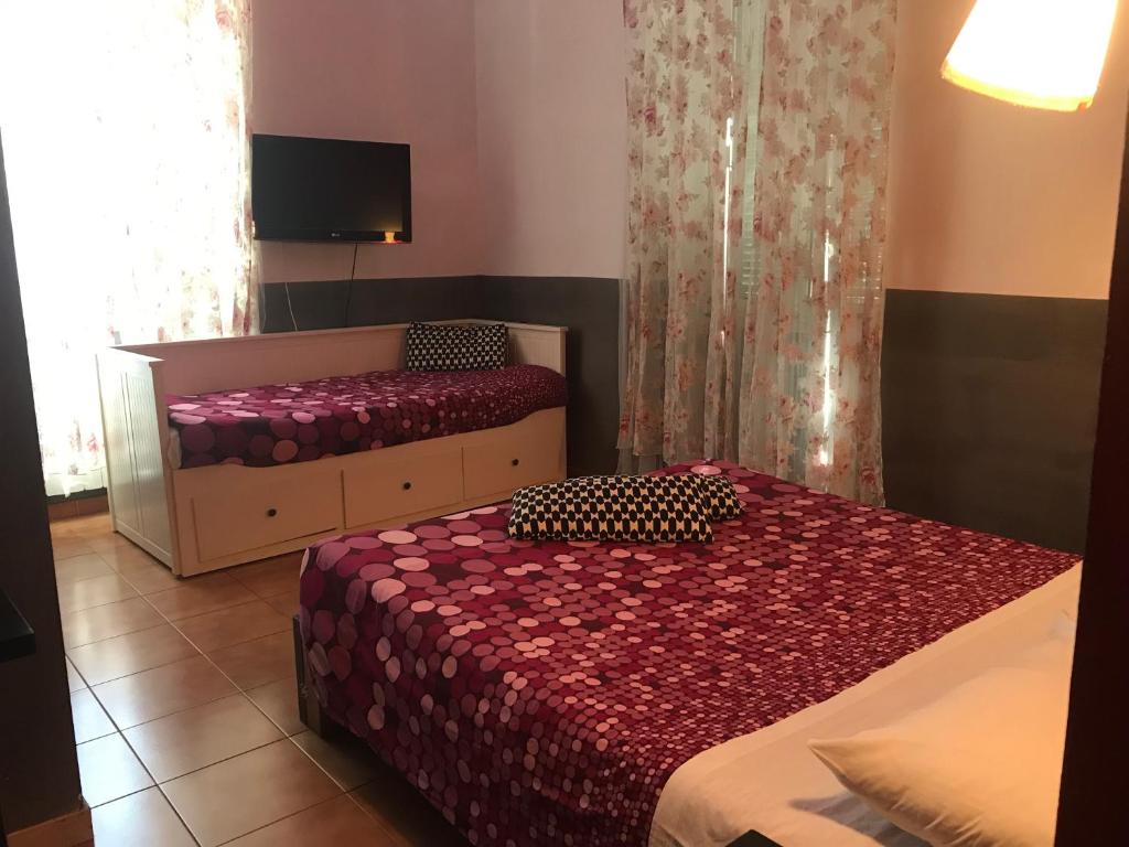sypialnia z dwoma łóżkami i telewizorem z płaskim ekranem w obiekcie La Casa di Elena w Rzymie