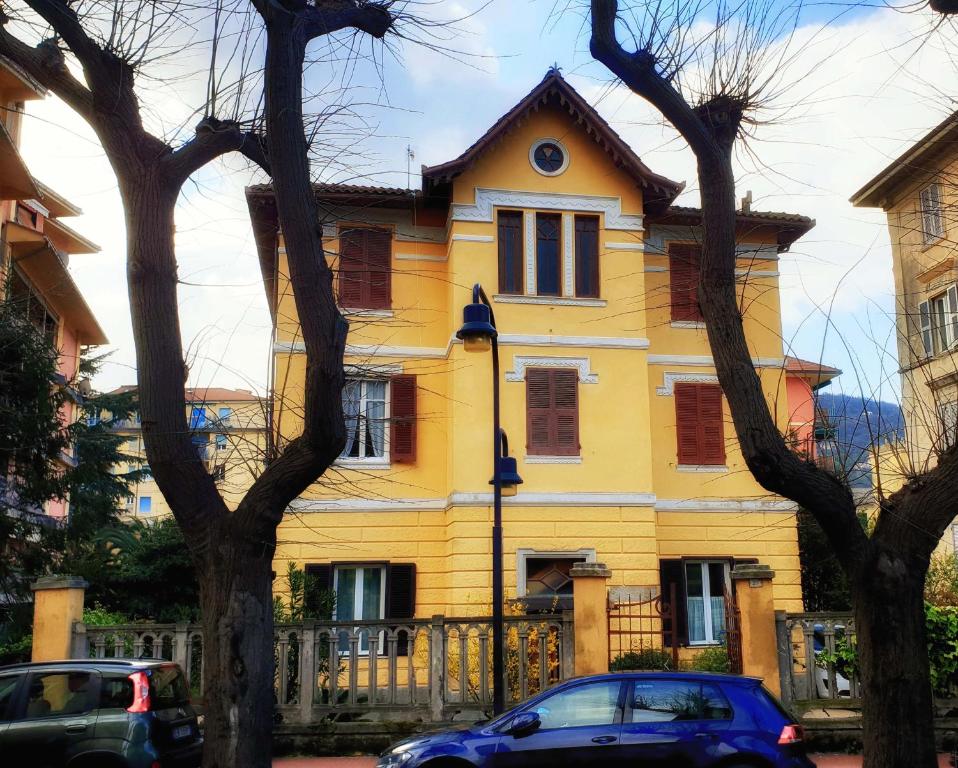 a yellow house with cars parked in front of it at Edera in Levanto