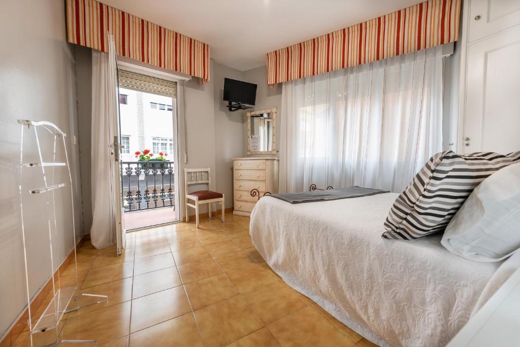 1 dormitorio con cama y ventana en Hospedaxe Maria Aguiño, en O Grove