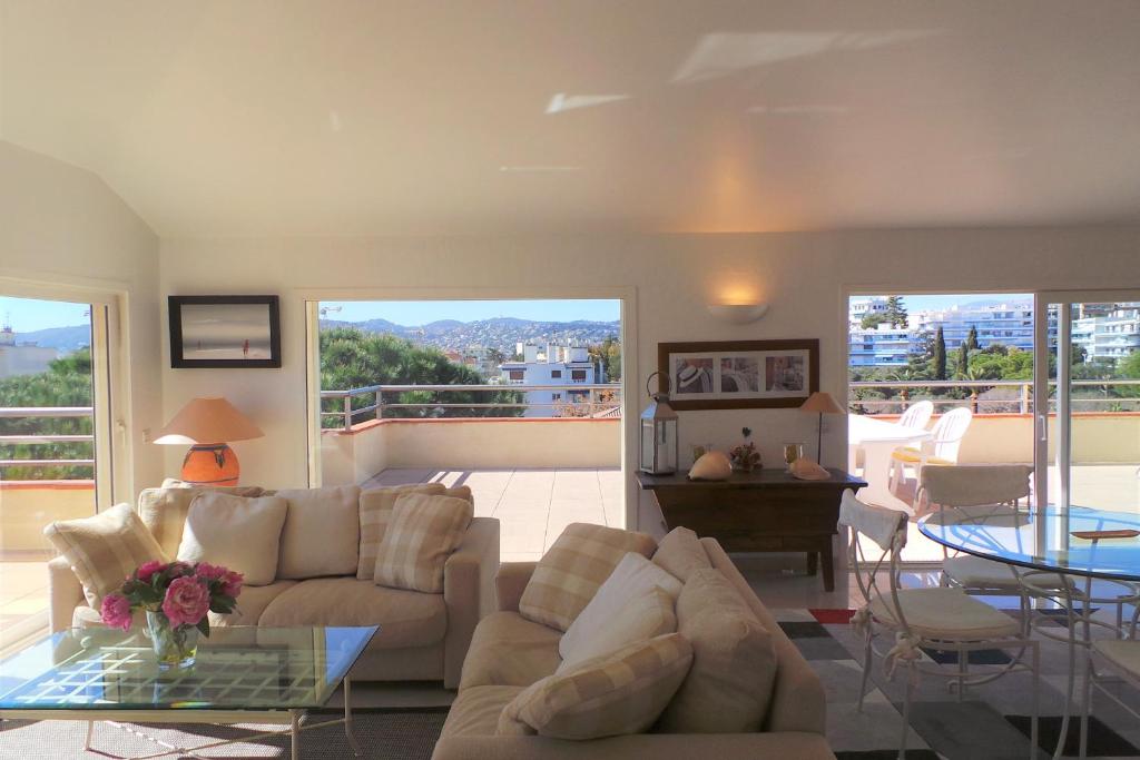 uma sala de estar com dois sofás e uma mesa de vidro em Spacious and bright flat Downtown and Beaches - Swimming Pool em Antibes