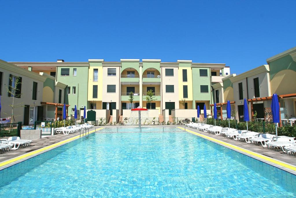 a swimming pool in front of some buildings at Farnie Lido Altanea in Caorle