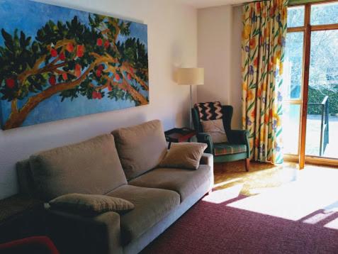 una sala de estar con sofá y una pintura en la pared en Dúplex con jardín en Ezcaray en Ezcaray