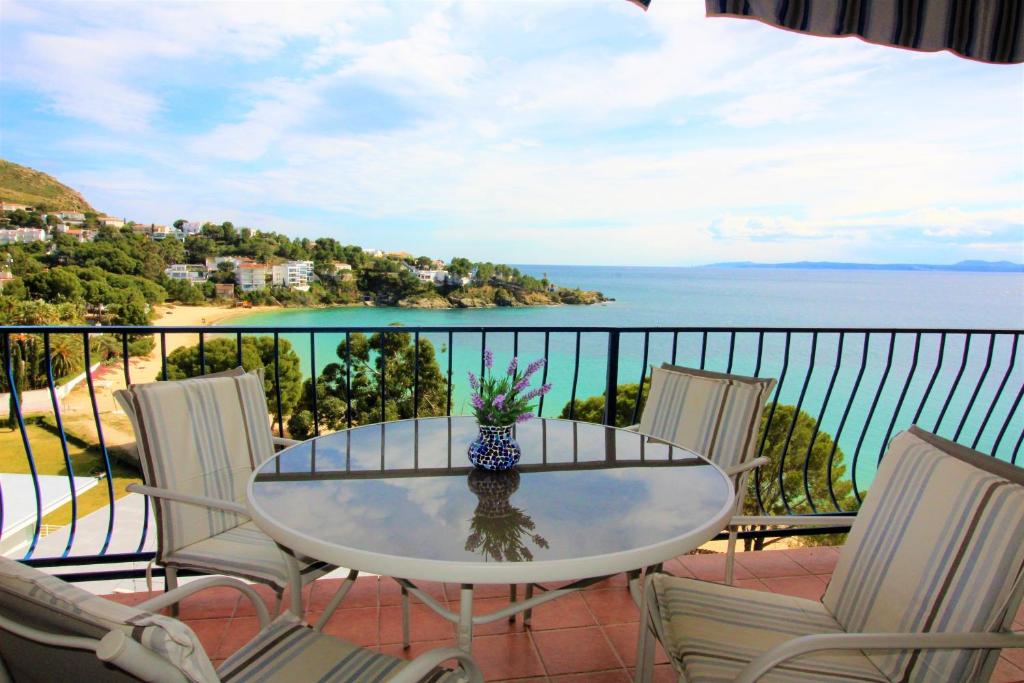 stół i krzesła na balkonie z widokiem na ocean w obiekcie Global Immo 3213 Horizonte Azul w mieście Roses